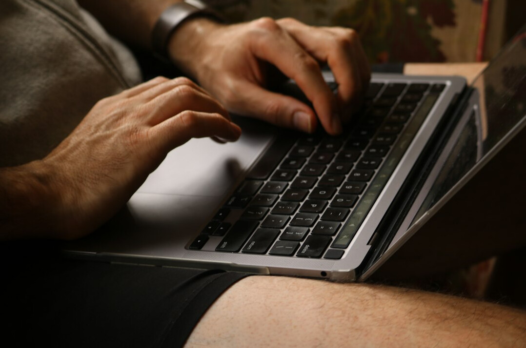 writer typing on laptop at night
