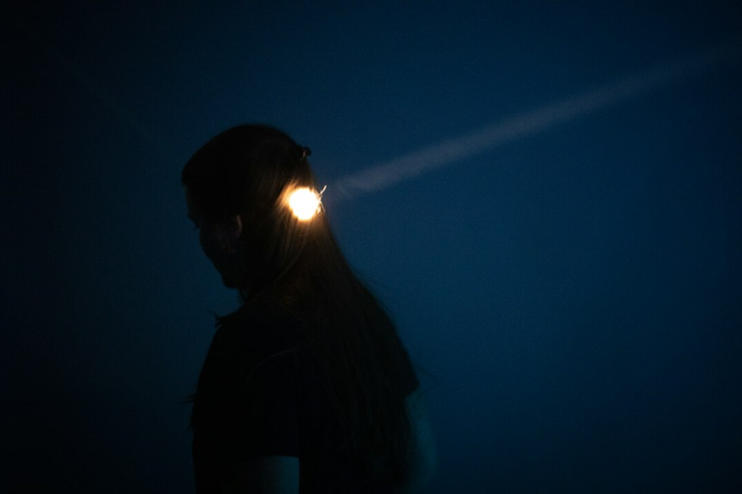 person with flashlight in dark